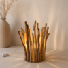 Petite lampe en bois flotté allumée dans une décoration beige