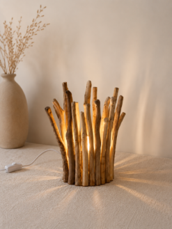 Petite lampe en bois flotté allumée dans une décoration beige