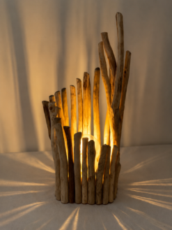 Lampe en bois flotté design allumée projetant des ombres lumineuses