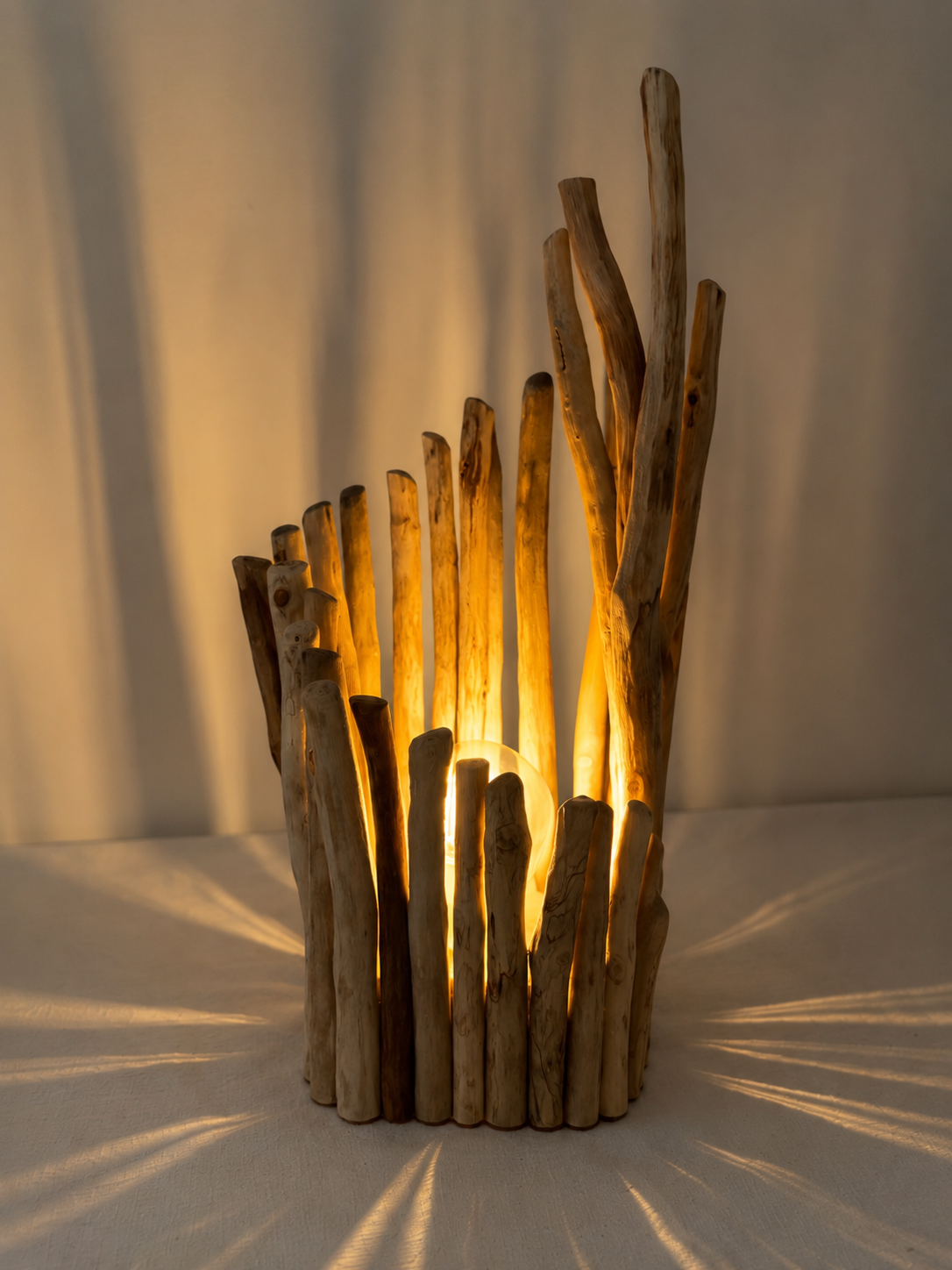 Lampe en bois flotté design allumée projetant des ombres lumineuses