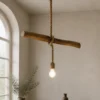 Suspension en bois flotté artisanale L’Équilibre du Rivage allumée dans une salle à manger